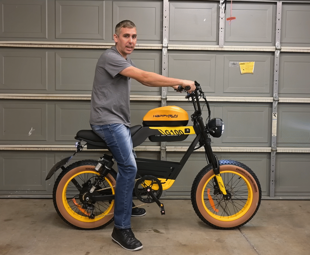 A person riding a yellow and black electric bike in a garage, showcasing the HappyRun G400 model.