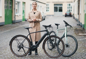 Cannondale Quick Neo SL 2 e-bike, standing next to a rider in an urban setting, highlighting its streamlined design and integrated motor.