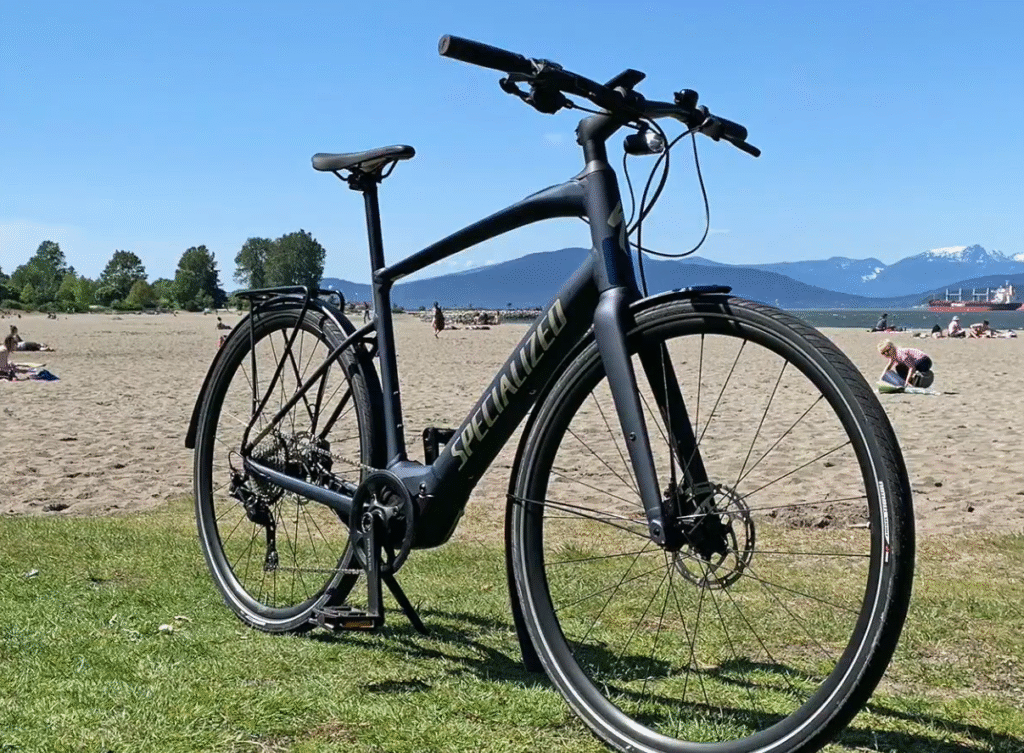 Specialized Turbo Vado SL 4.0, a sleek and modern e-bike on a sandy beach, showcasing its minimalist frame and smooth lines.