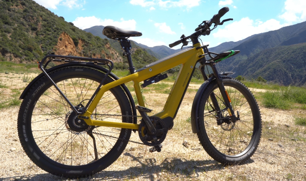 Riese & Müller Supercharger2 in a rugged outdoor setting, featuring dual batteries and a powerful Bosch motor for long-range rides.