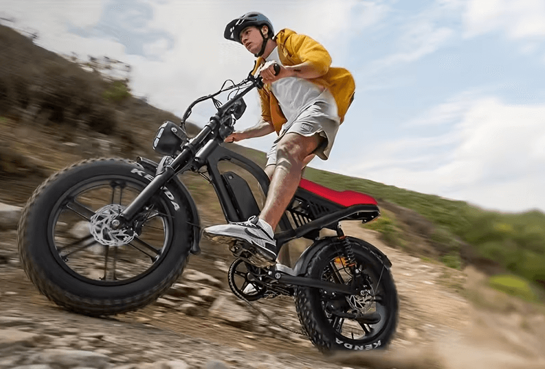 Are Electric Bikes Available for Purchase on Temu? 1 Young man climbing a rocky hillside on a fat-tire electric bike, wearing a helmet and yellow jacket.